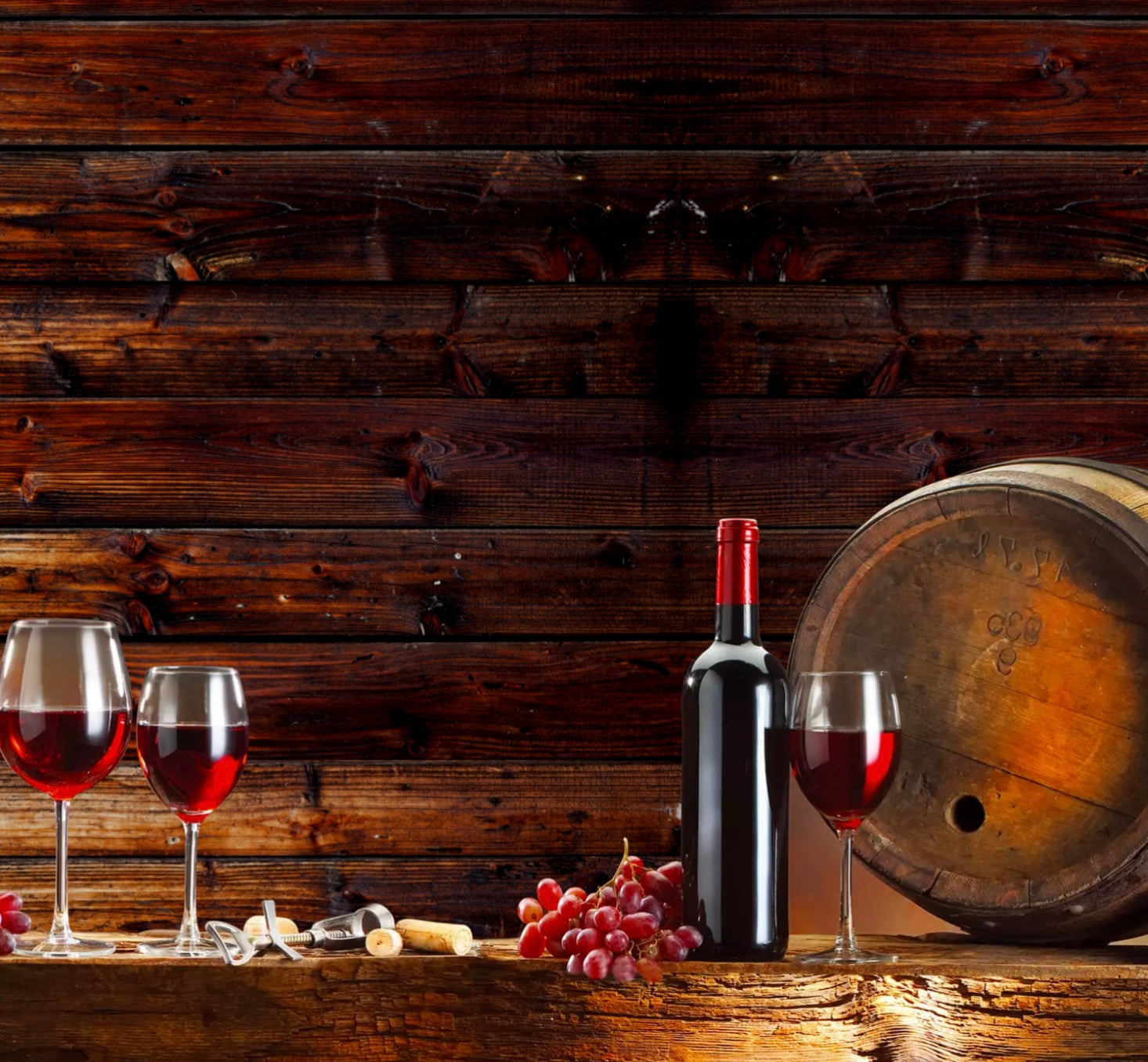 Wine bottle and glasses on a wooden table with a wooden background
